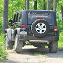 Jeep® Off Road Driving Back of a black Jeep® going off-road into the woods.