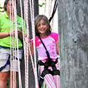 Child about to climb through a slightly elevated adventure ropes course.
