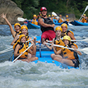 Group of six white water rafting with a guide.