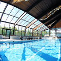 Indoor lap pool with large open windows to let the sun in.